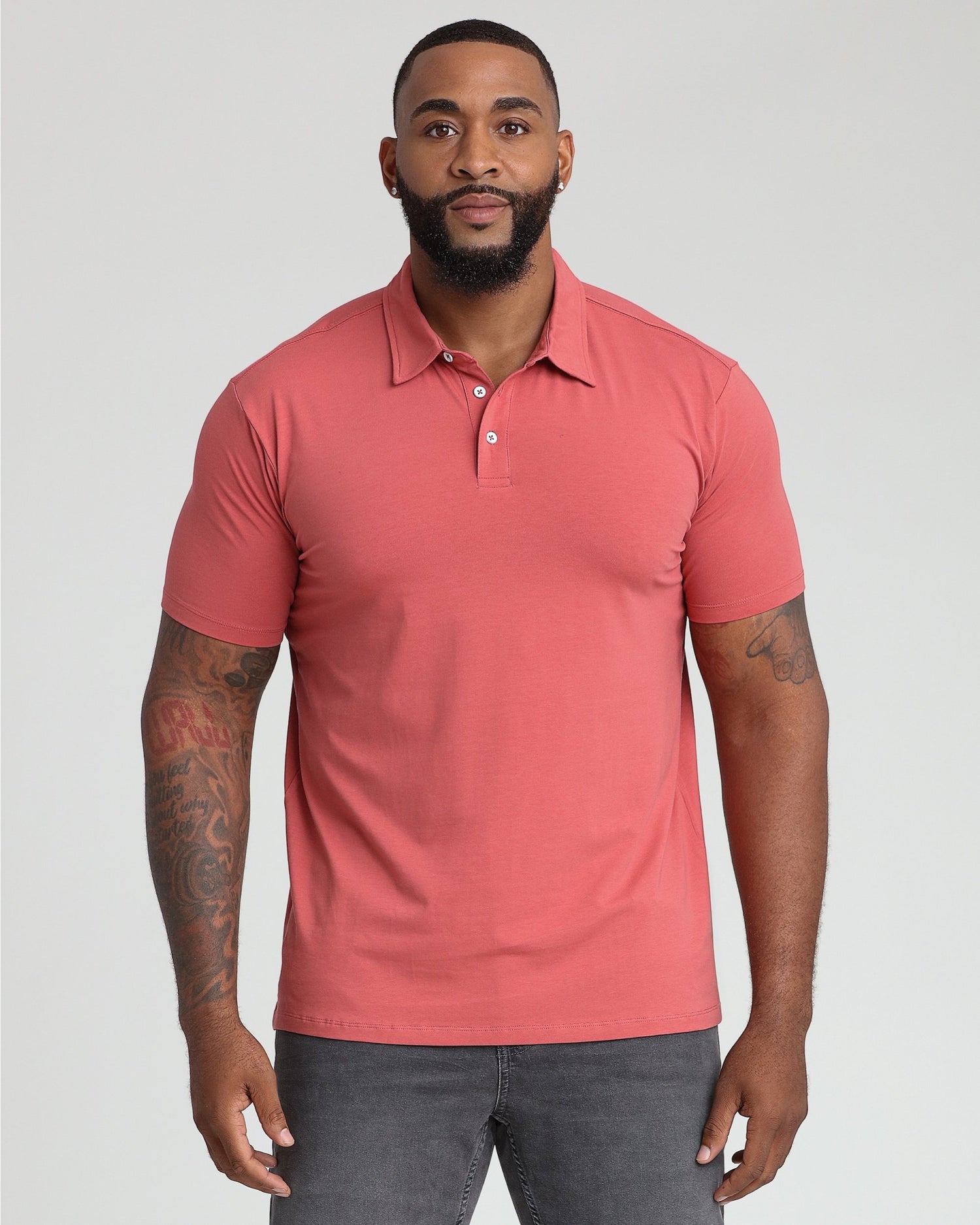 Man wearing Nantucket red short-sleeve polo shirt with white button placket and collar.