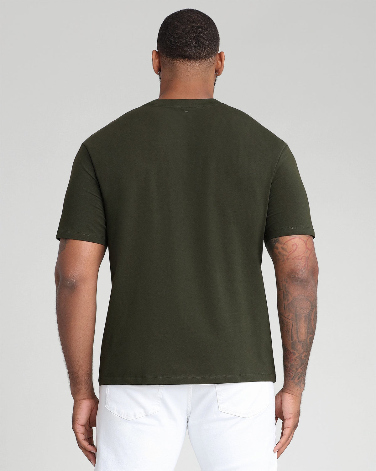 Olive crew neck t-shirt with short sleeves, shown back view on model wearing white pants.