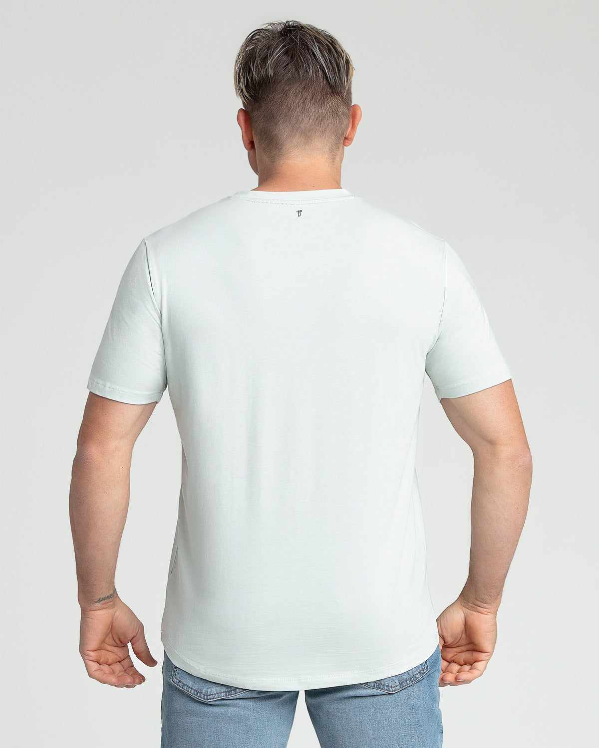 Mint green V-neck t-shirt with short sleeves, shown on a man from behind wearing blue jeans.