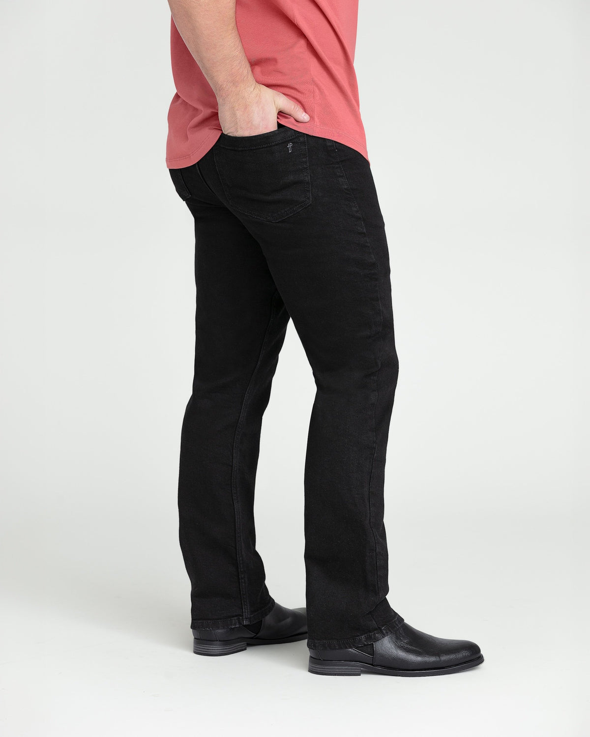 Black bootcut jeans with a slight flare at the hem, shown on a model wearing a pink shirt and black boots.