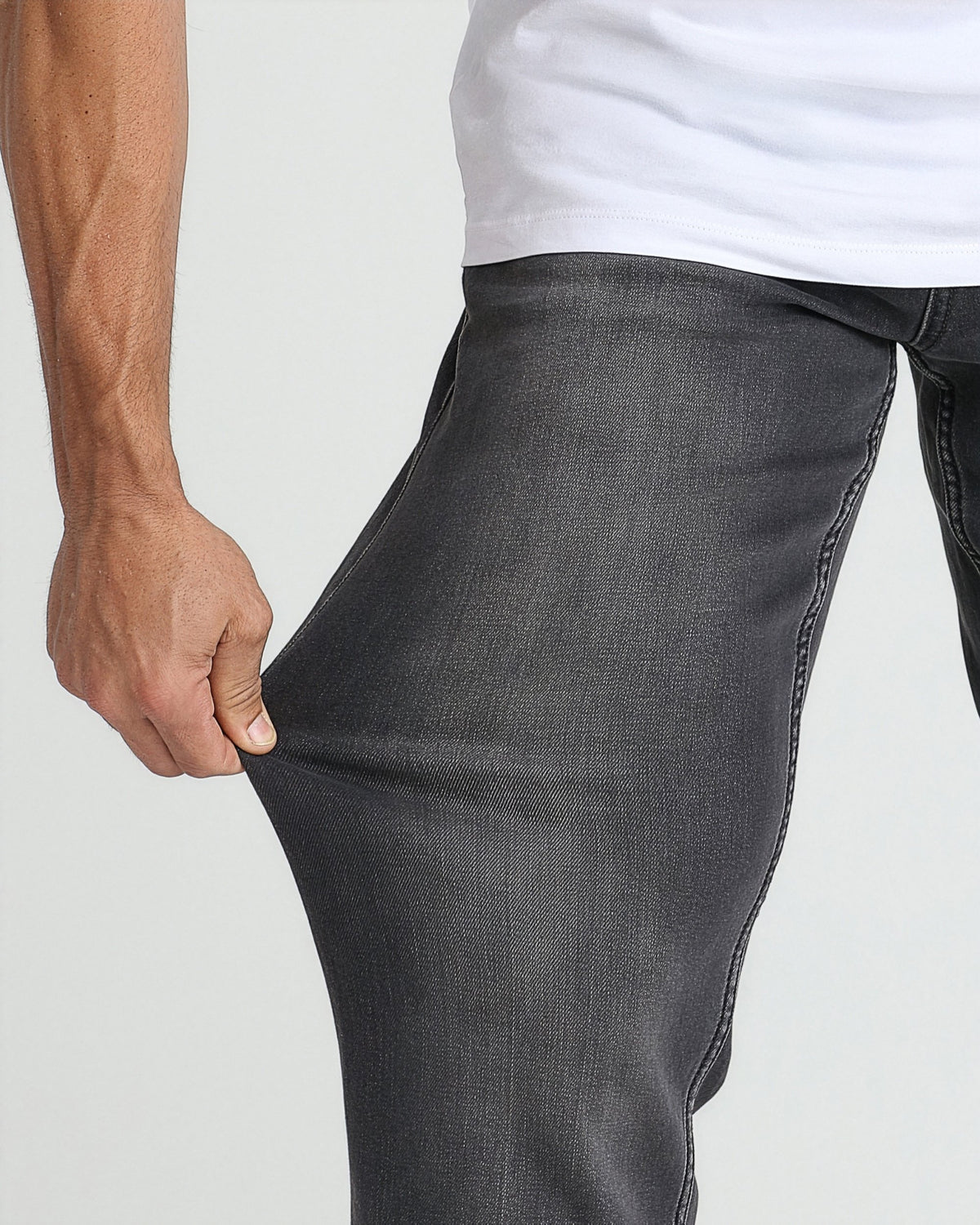 Charcoal grey denim jeans with relaxed fit shown on model wearing white t-shirt.