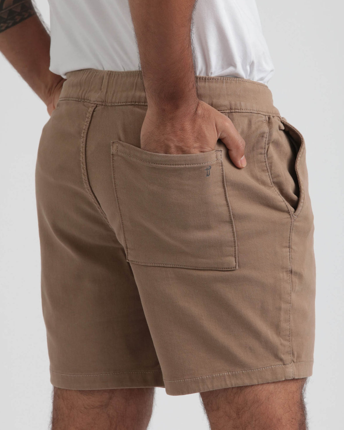 Dark khaki shorts with elastic waistband and front patch pocket, worn with white t-shirt.