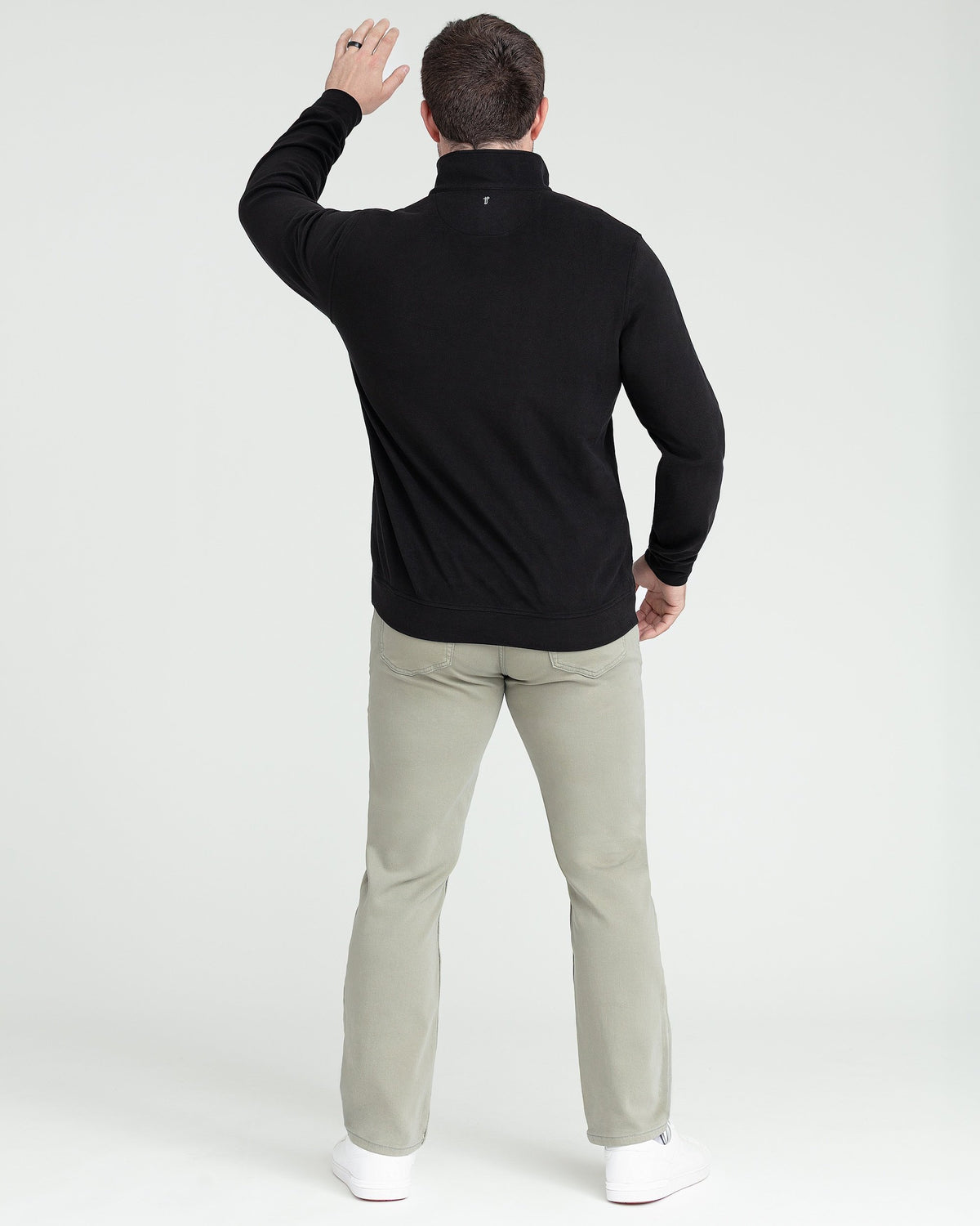 Black quarter zip pullover with stand collar, shown from back on model wearing tan pants.