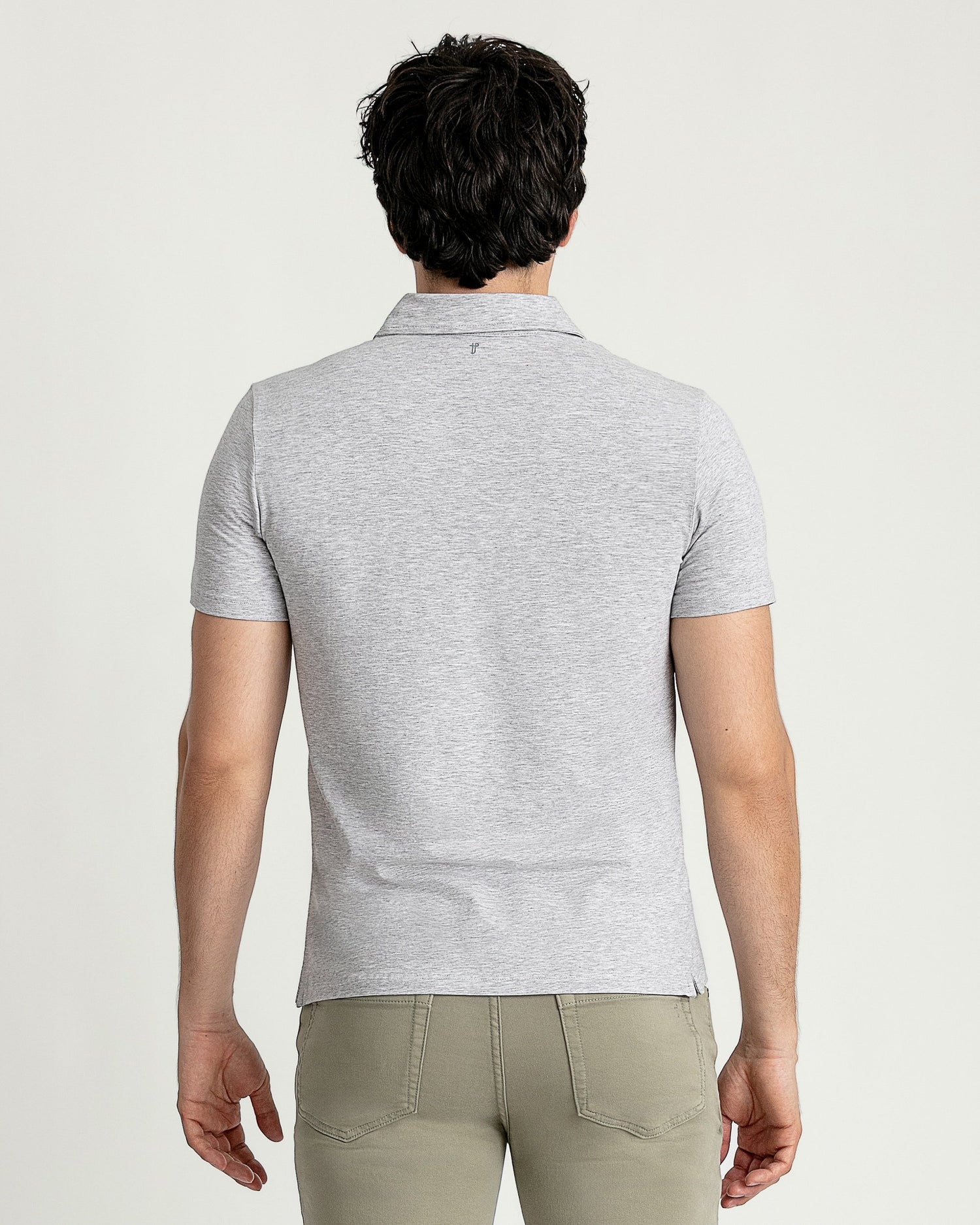 Man wearing light gray short-sleeve polo shirt with collar, shown from back view.