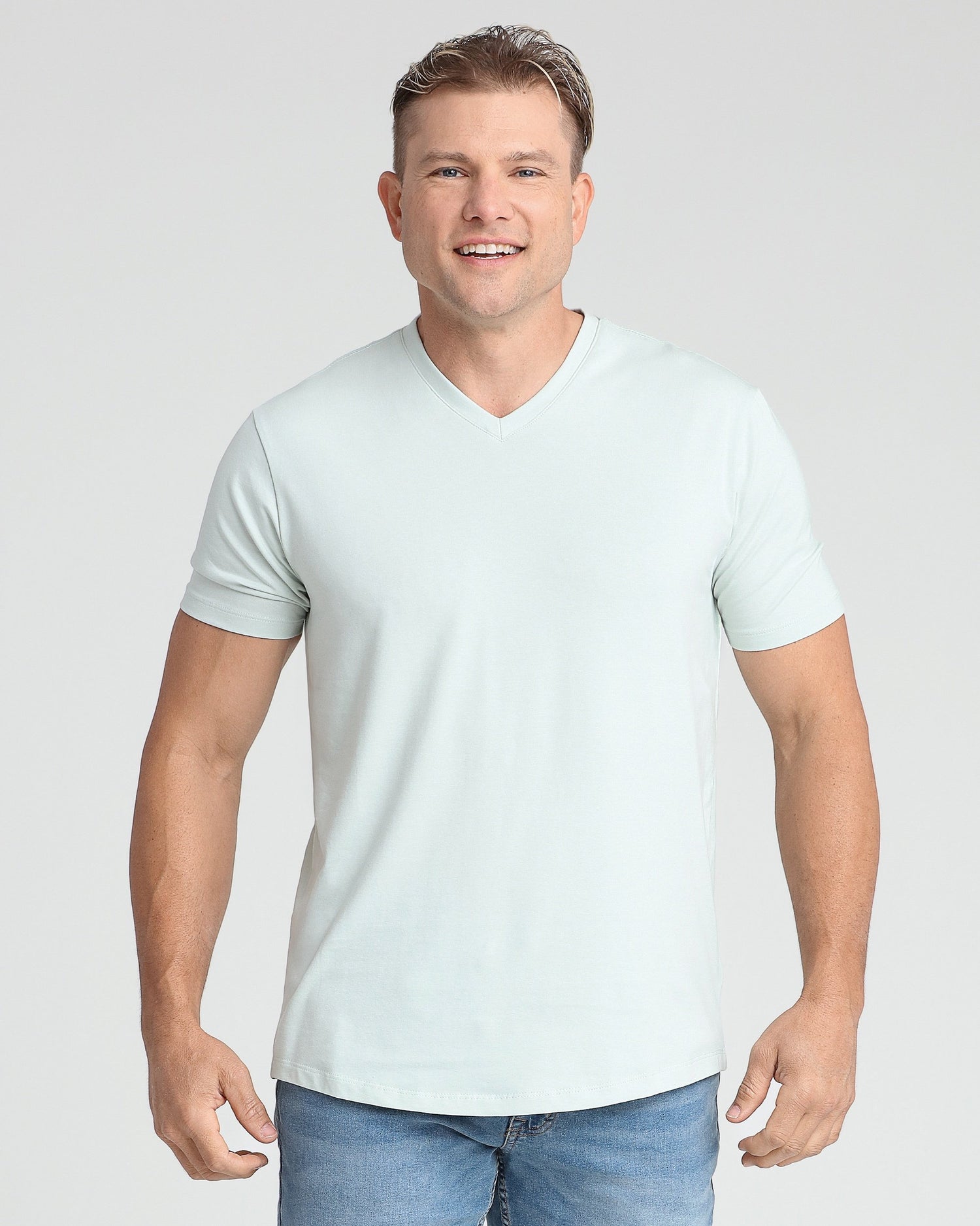 Man wearing light blue v-neck short-sleeve t-shirt with blue jeans.