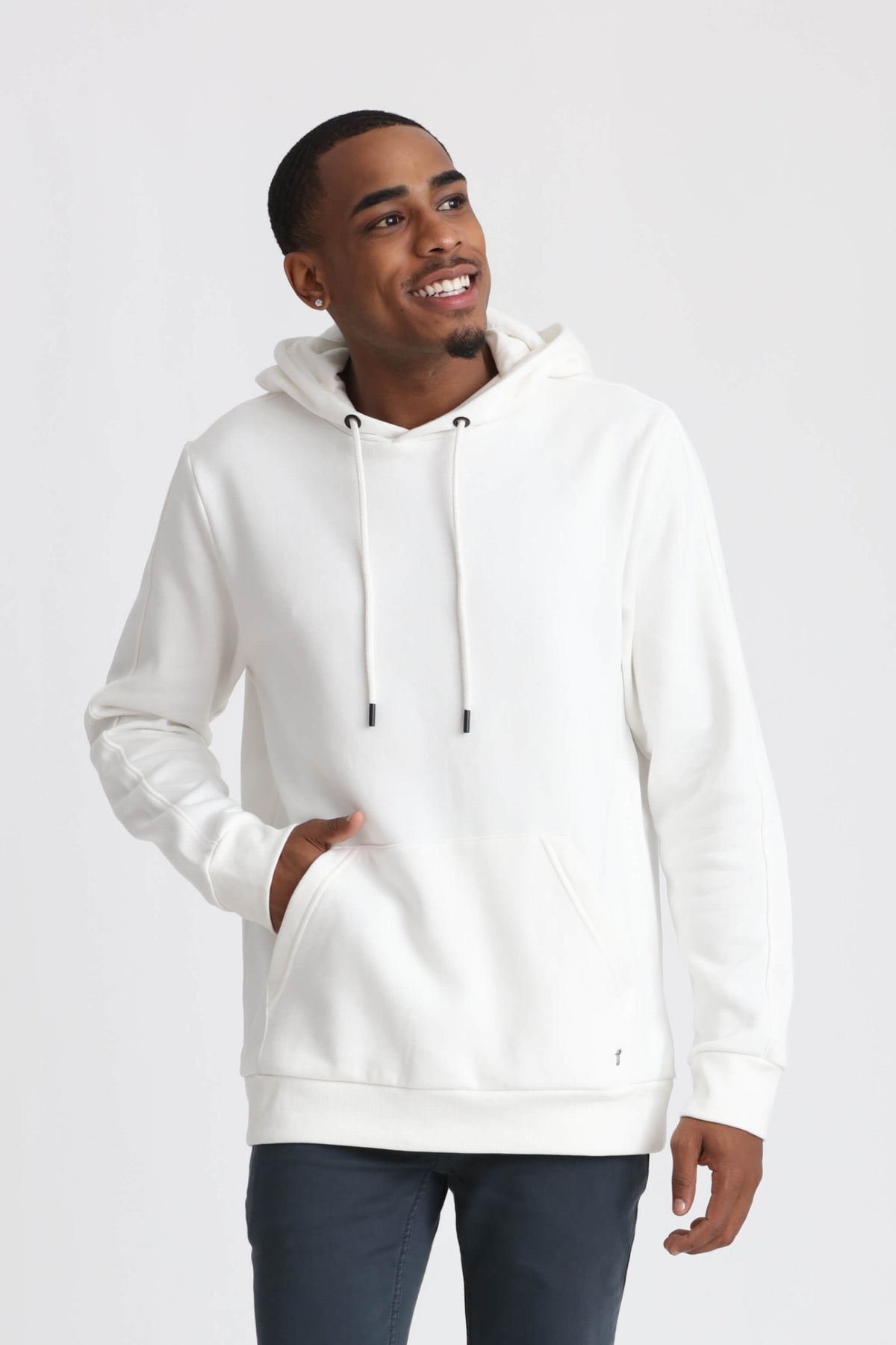 White pullover hoodie with drawstring and kangaroo pocket, worn with dark pants.
