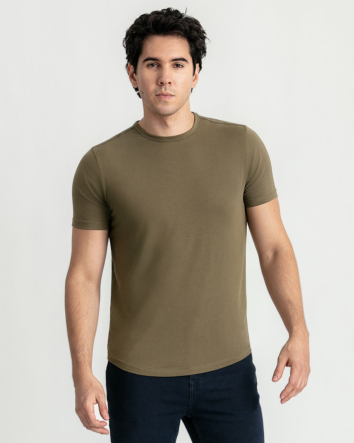 Man wearing olive-green crew neck t-shirt with short sleeves and dark pants.