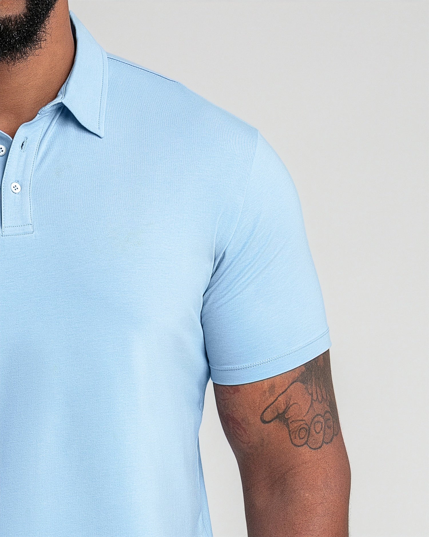 Light blue polo shirt with collar and button placket on male model.