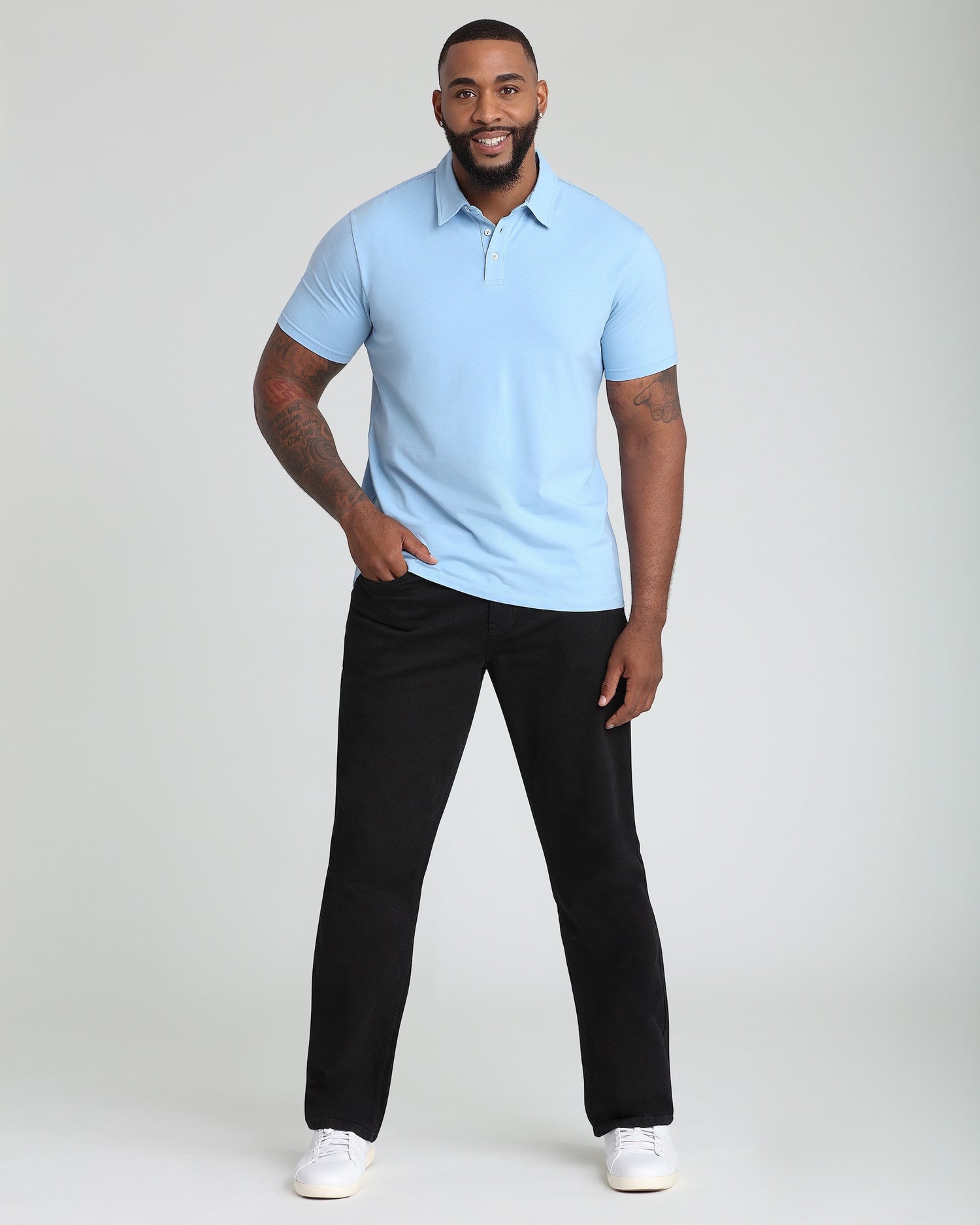 Man wearing light blue short-sleeve polo shirt with collar and black pants.