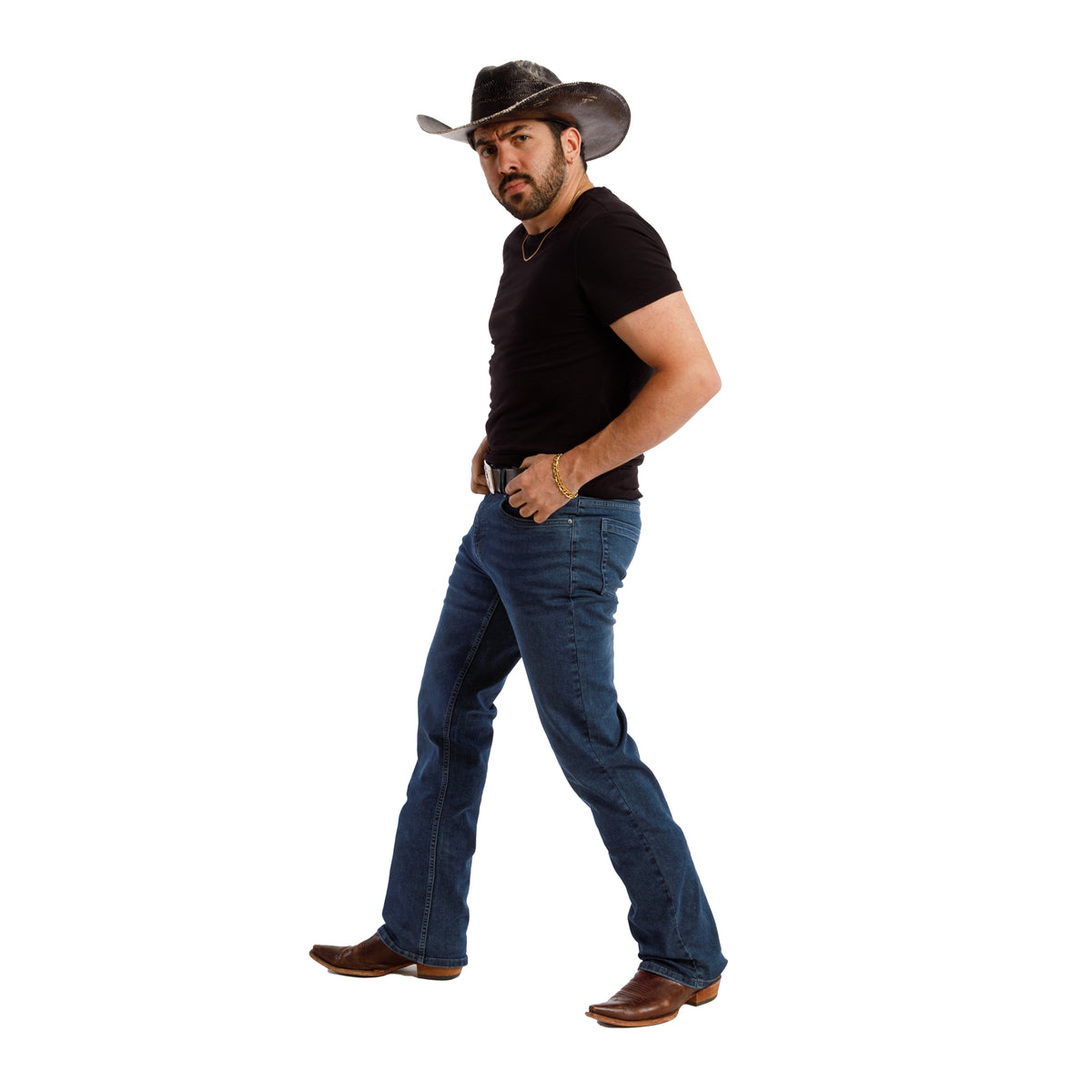Man wearing dark blue bootcut jeans with black t-shirt and brown boots, shown in side profile.